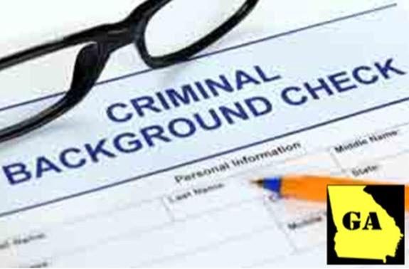Criminal background check form with Georgia state icon highlighted on desk with glasses and pen.